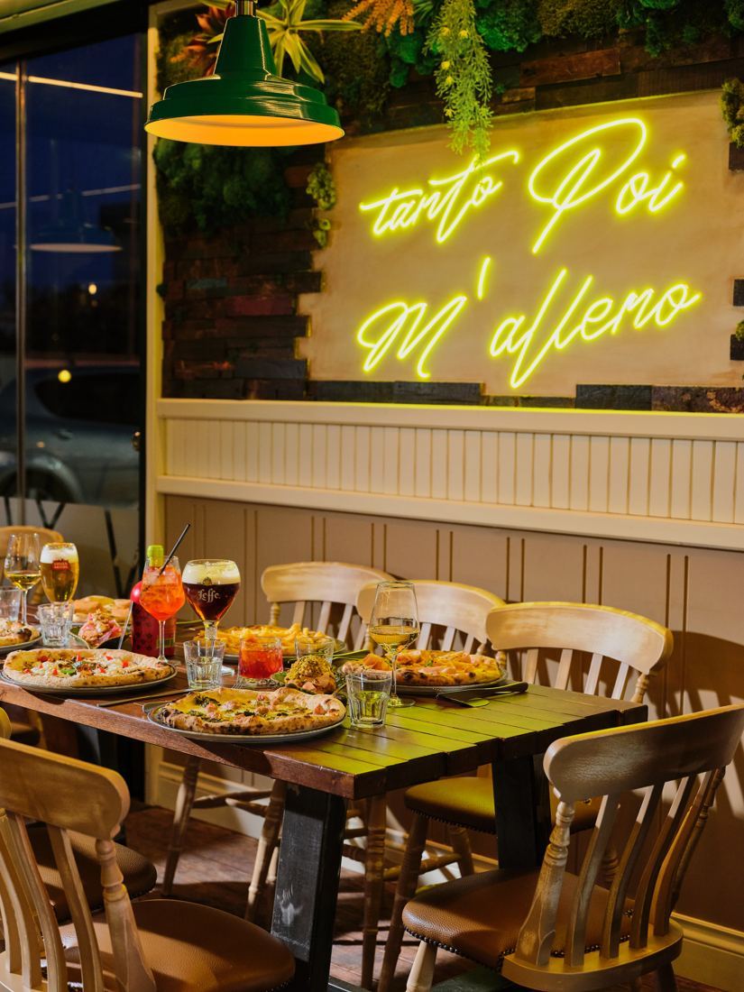 L’insegna al neon «Tanto poi m’alleno» nella sala di Lyevitò