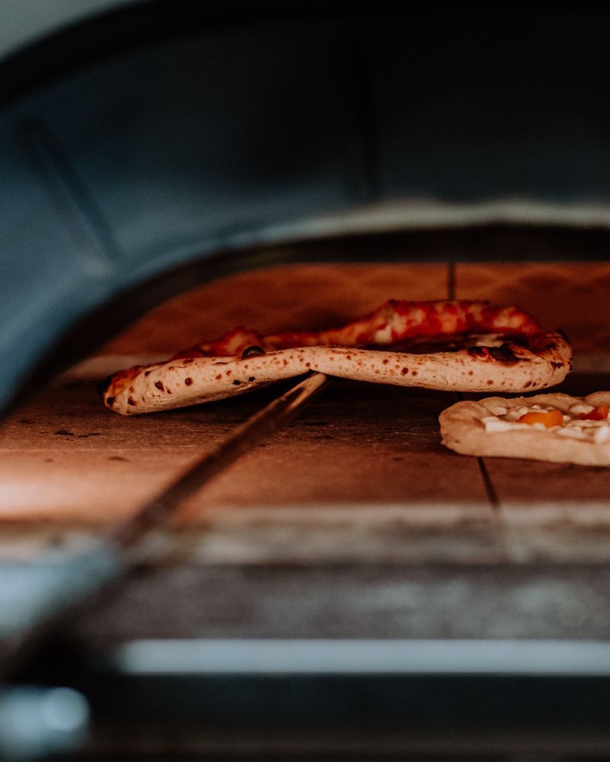 Due pizze in teglia nel forno durante la prima cottura
